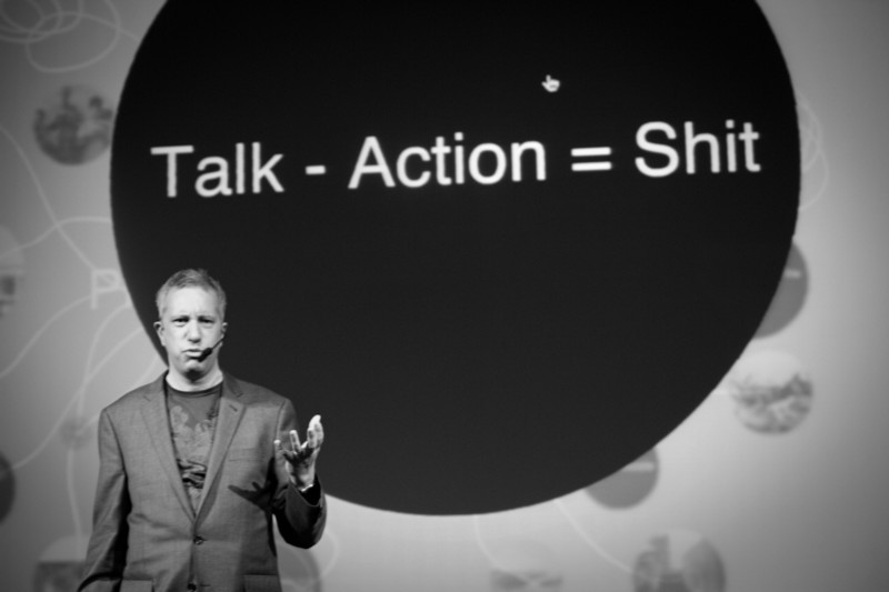 Brendan Dawes in front of one of their slides written: "Talk - Action = Shit"